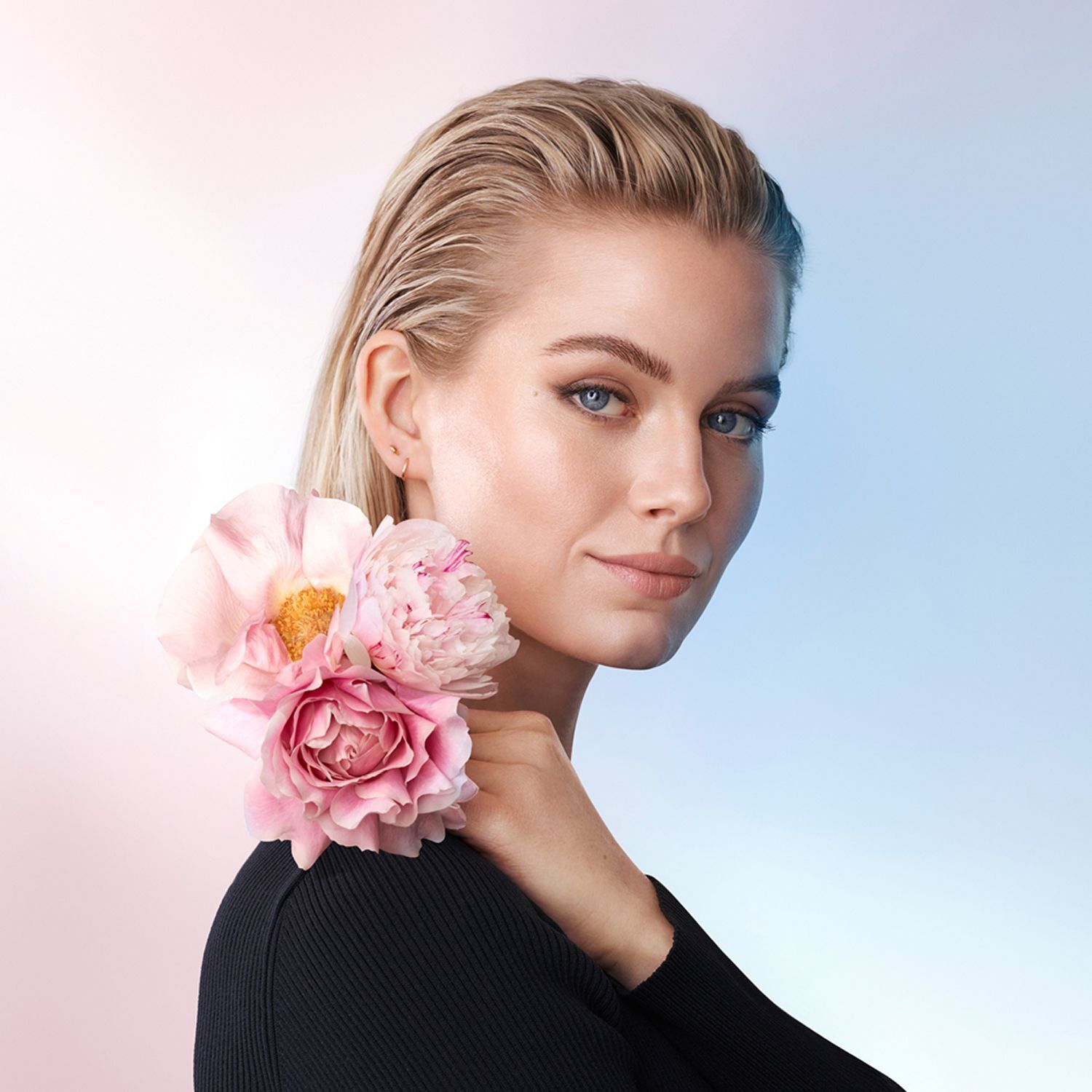 Porträt einer Frau mit Rosenblüten, die Annemarie Börlind Rose Nature repräsentieren.