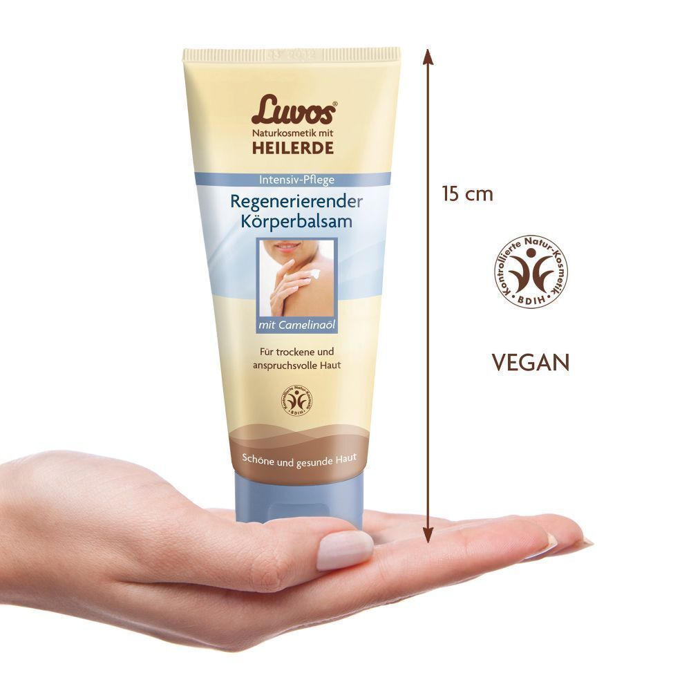 Körperbalsam-Tube in Hand. Beige Tube mit blauem Deckel. Aufschrift: Luvos Heilerde, Regenerierender Körperbalsam. Größe: 15 cm.