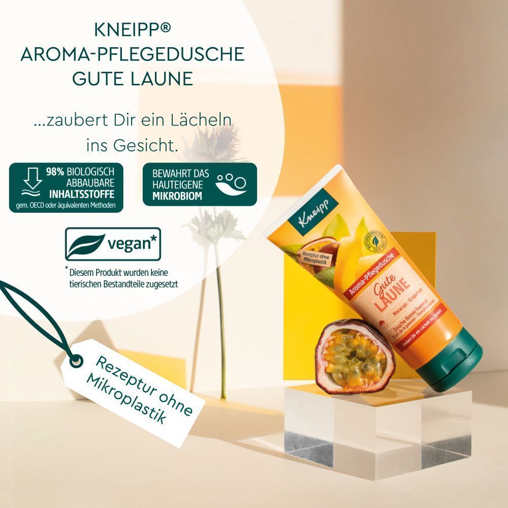 Kneipp® Aroma-Pflegedusche Gute Laune. Tube auf Podest, Maracuja-Hälfte, Text: 98% biologisch abbaubare Inhaltsstoffe, vegan, Rezeptur ohne Mikroplastik.