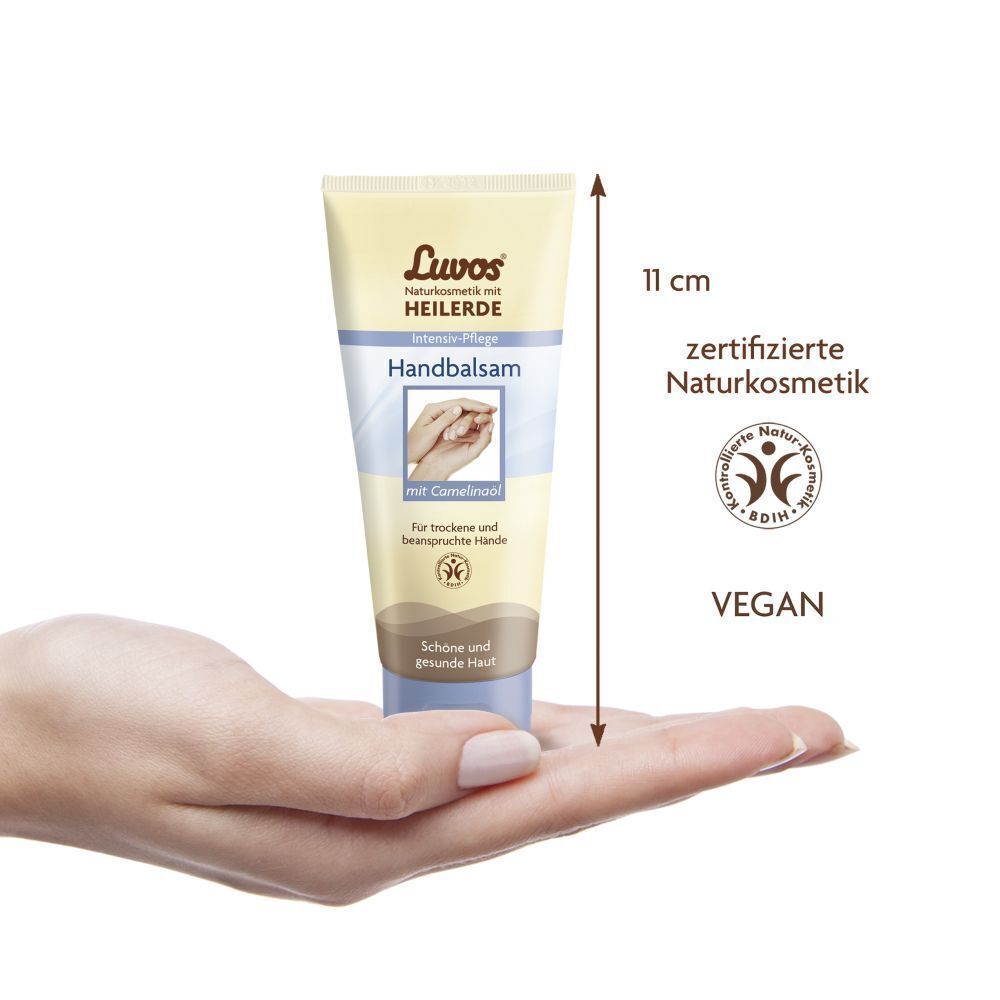 Handbalsam-Tube in Hand gehalten. Beige-blaue Verpackung. Länge ca. 11 cm. Vegan-Siegel und Naturkosmetik-Zertifizierung.