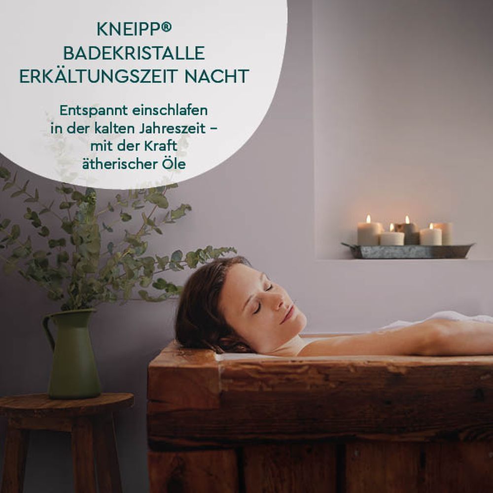 Frau in Holzbadewanne. KNEIPP Badekristalle Erkältungszeit Nacht. Kerzen. Hintergrund: Grau-weiß. Text: Entspannt einschlafen.