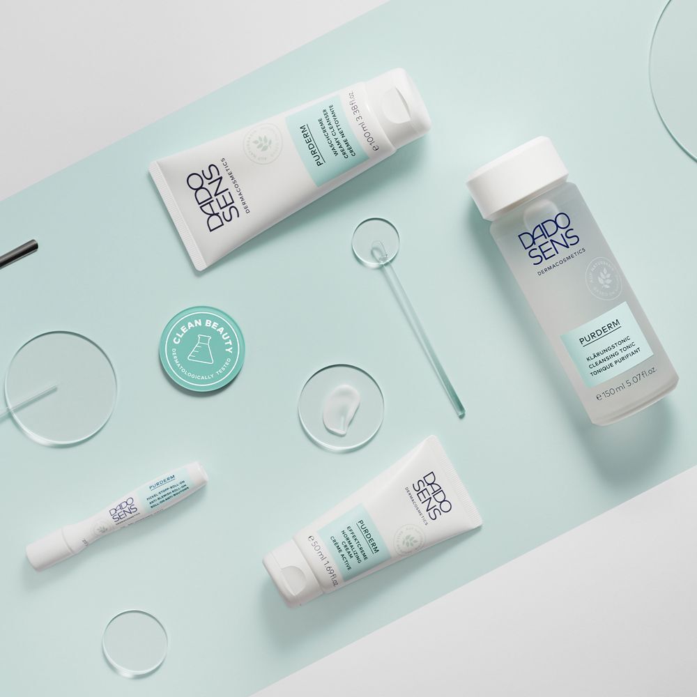 Mehrere DADO SENS PURDERM Produkte arrangiert auf einem hellblauen Hintergrund.