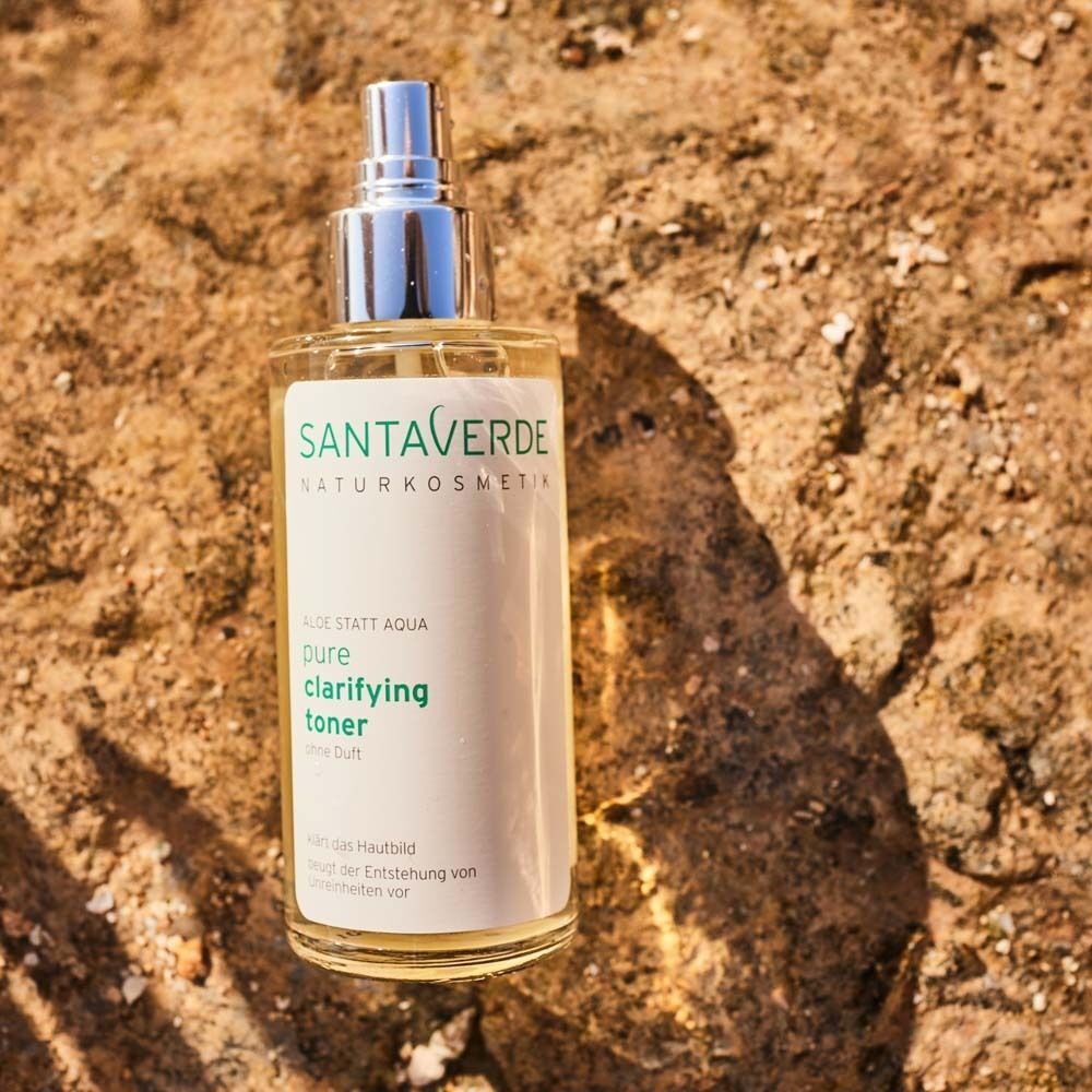 SANTAVERDE Toner-Flasche auf Stein. Klare Flüssigkeit in Glasflasche mit Sprühkopf. Aufschrift: pure clarifying toner.