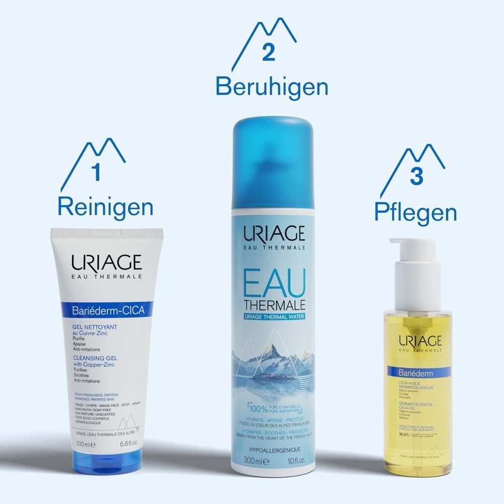 Produkt URIAGE® Bariéderm-CICA Öl neben Verpackung. Flasche mit weißem Pumpkopf. Verpackung mit Produktname und Inhaltsangaben.