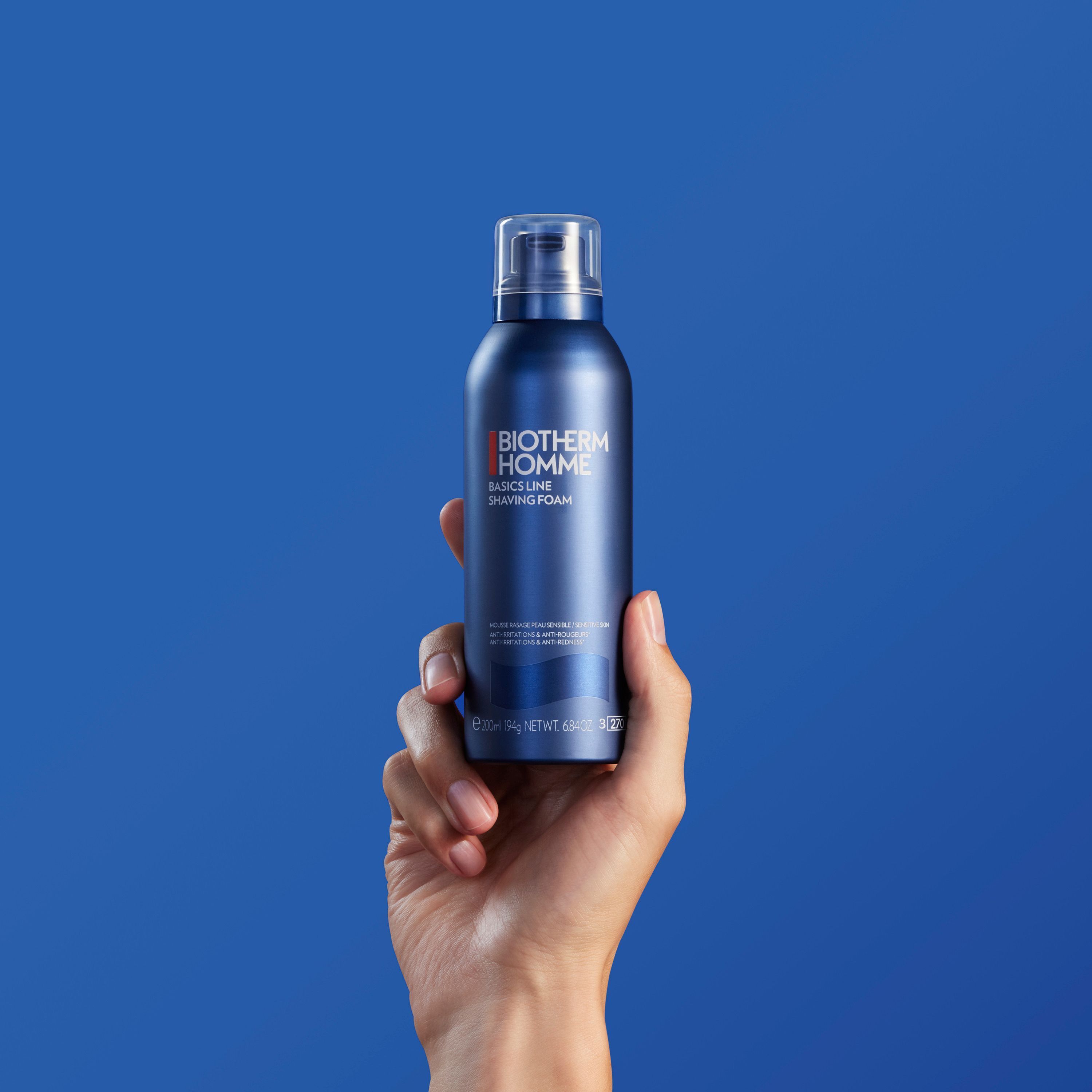 Hand hält eine blaue Sprühdose. Aufschrift: BIOTHERM HOMME, BASICS LINE SHAVING FOAM.
