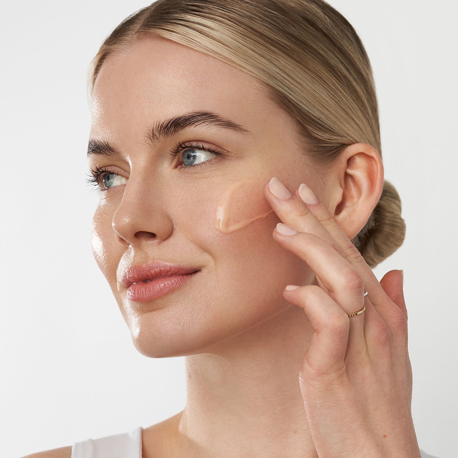 Eine Frau trägt ANNEMARIE BÖRLIND Rose Nature Night Repair Drops auf ihr Gesicht auf.