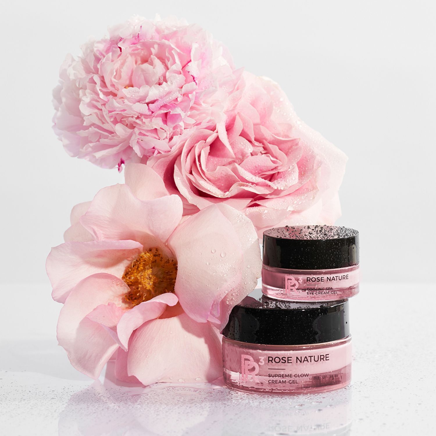 Zwei Tiegel ANNEMARIE BÖRLIND Rose Nature Cooling Spa Eye Cream Gel neben rosa Rosen.