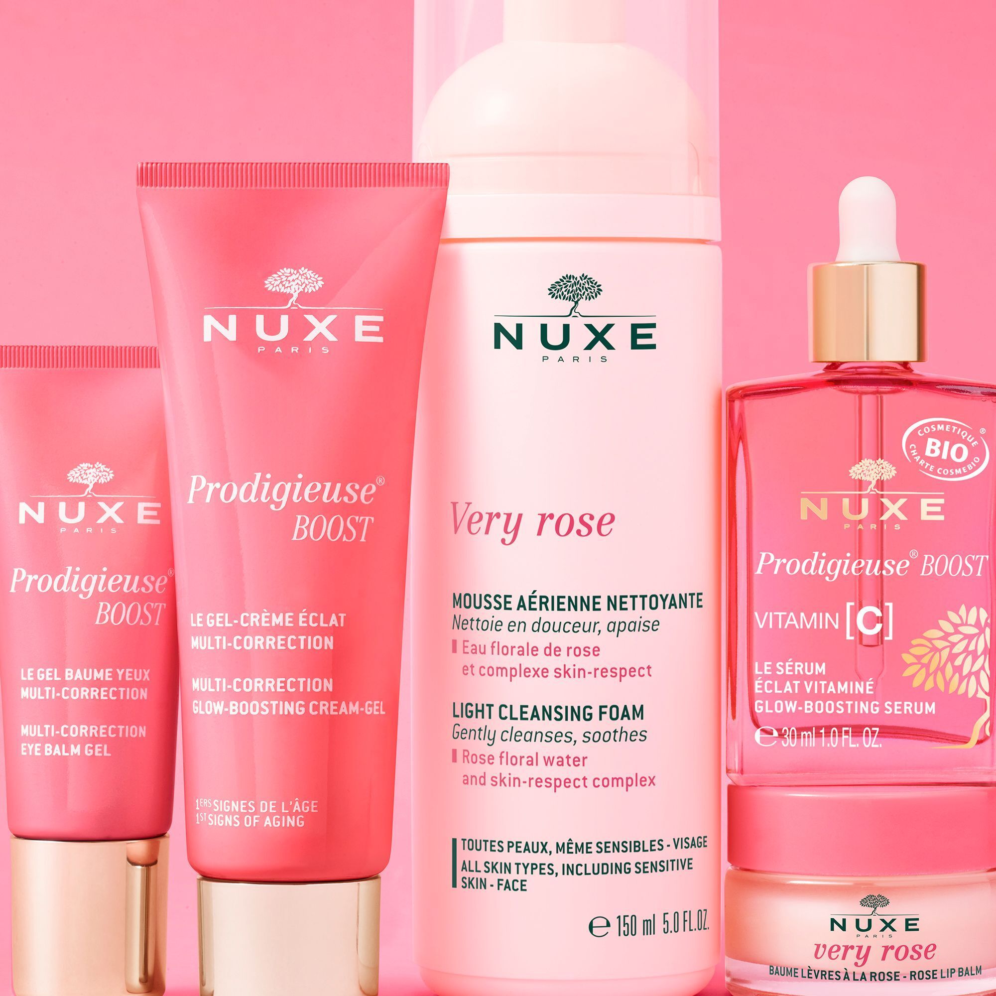 Mehrere rosa Produkte mit goldfarbenen Verschlüssen. Text: "NUXE Paris", "Prodigieuse Boost", "Very rose" und "Vitamin C".
