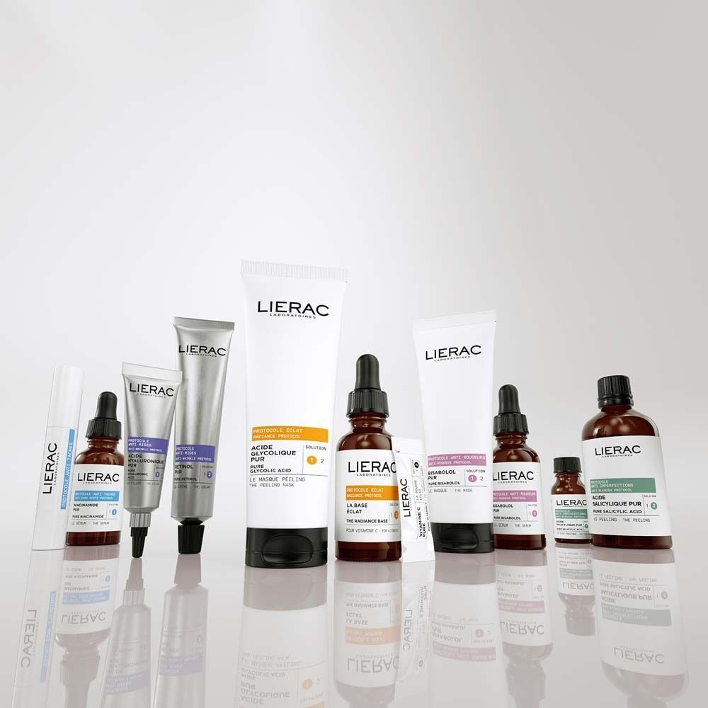 Verschiedene Kosmetikprodukte, darunter Flaschen und Tuben. Etiketten mit Produktnamen und Text: LIERAC, ACIDE SALICYLIQUE PUR, PROTOCOLE ANTI-IMPERFECTIONS.