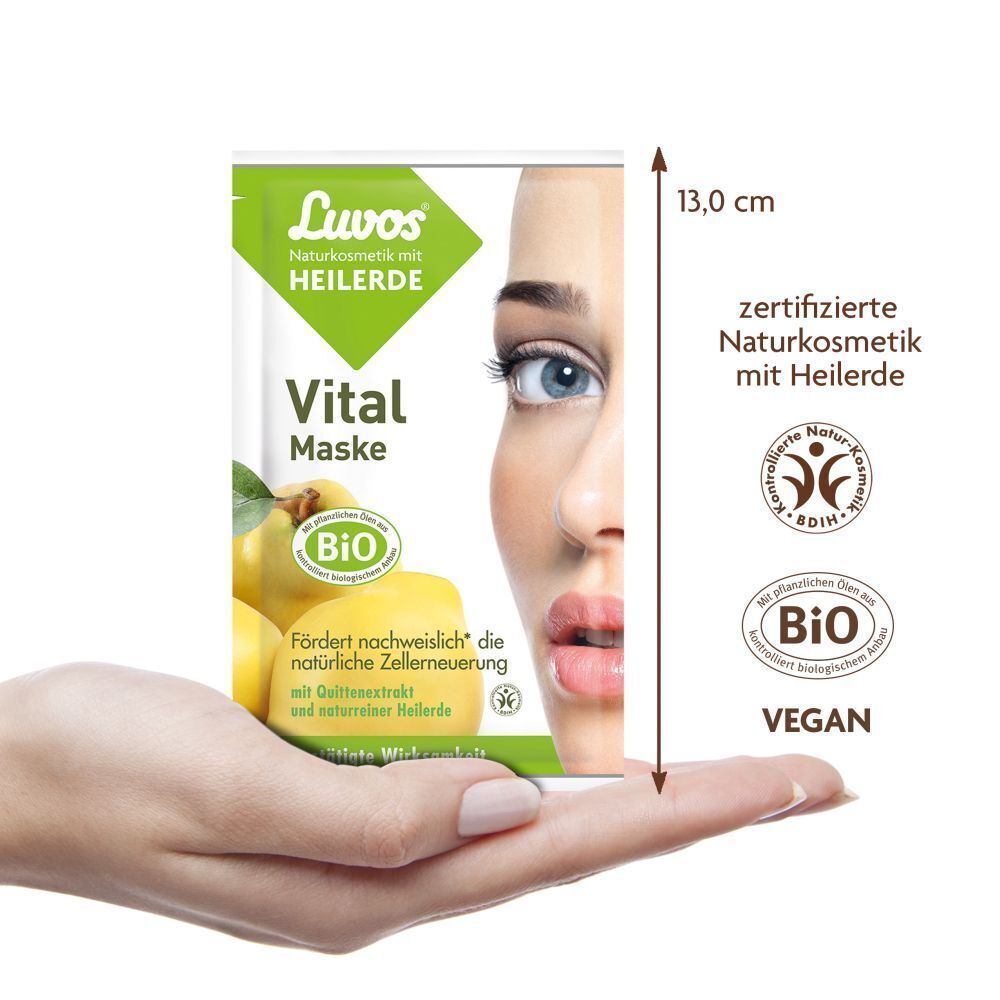 Hand hält ein Luvos Vital Maske-Beutel. Grün-weiß Verpackung mit Produktname, Logo und Gesicht. BIO-Siegel. Größe: 13,0 cm.