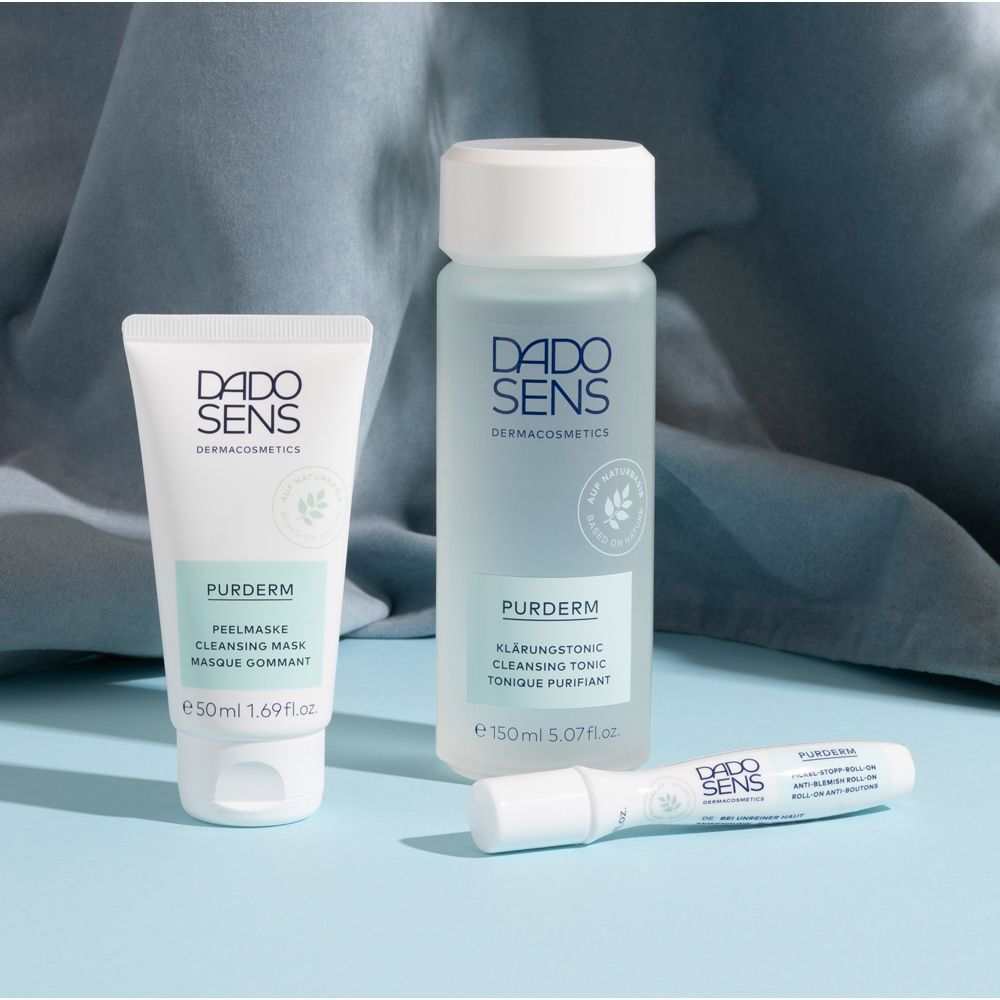 DADO SENS PURDERM Peelingmaske und Gesichtswasser auf blauem Hintergrund.