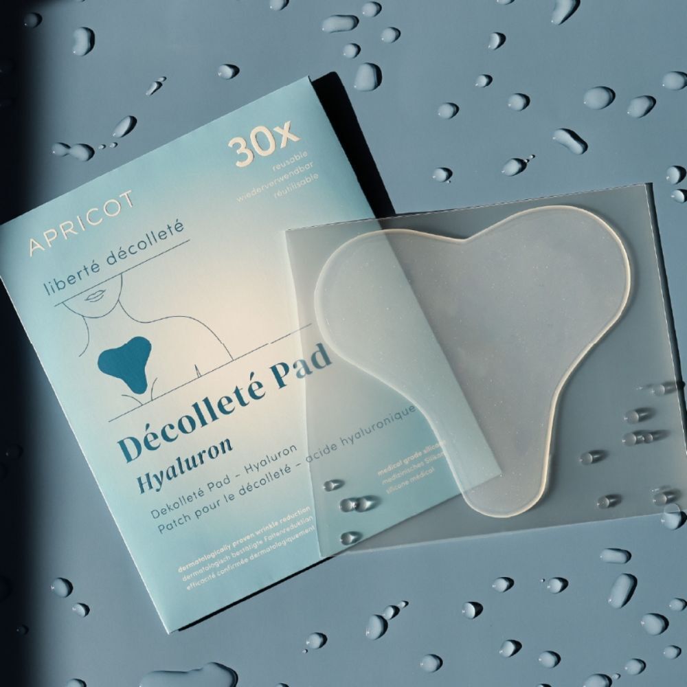 APRICOT Décolleté Pad Hyaluron Verpackung und ein einzelnes Pad auf blauem Hintergrund.
