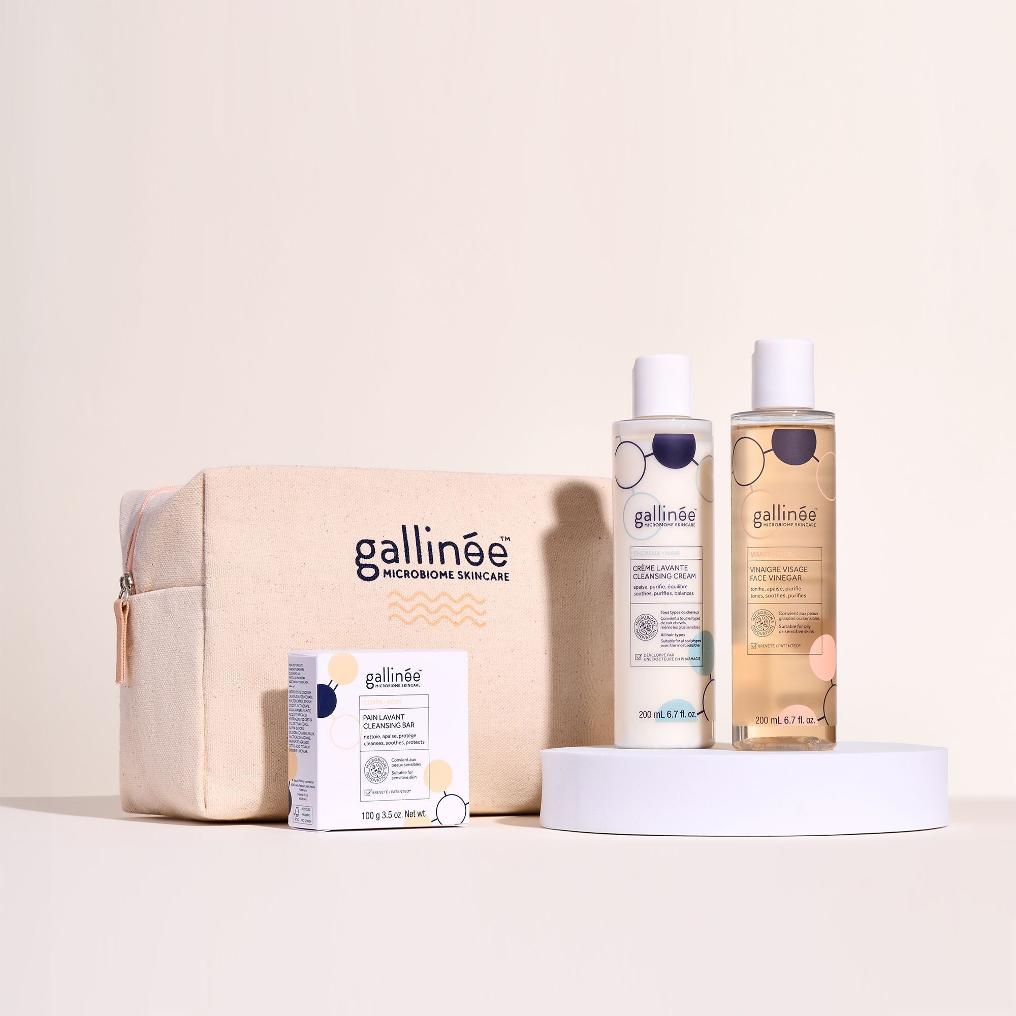 Set mit Kosmetiktasche, Seife und zwei Flaschen. Aufschrift: gallinée. Produkte stehen auf einer weißen Plattform.