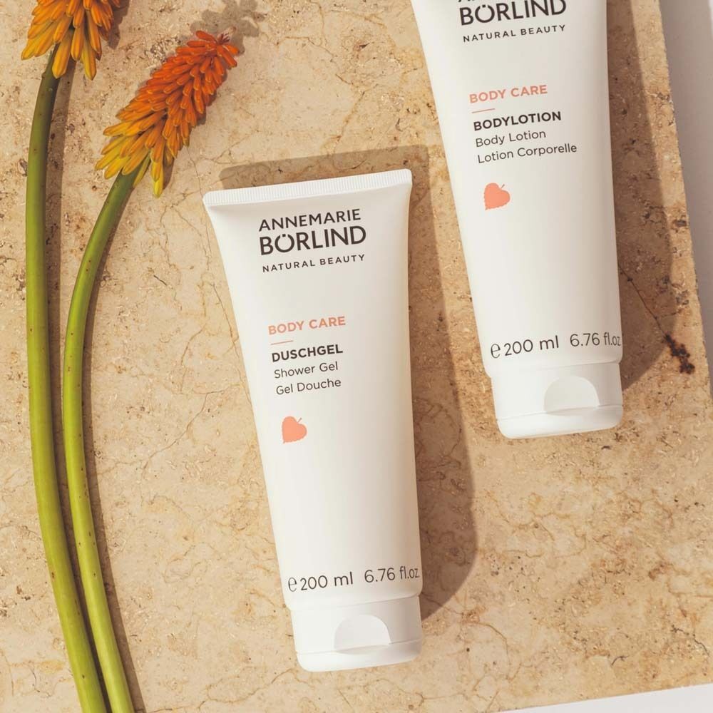 Eine Tube ANNEMARIE BÖRLIND Duschgel und eine Tube Bodylotion auf einer Steinplatte.