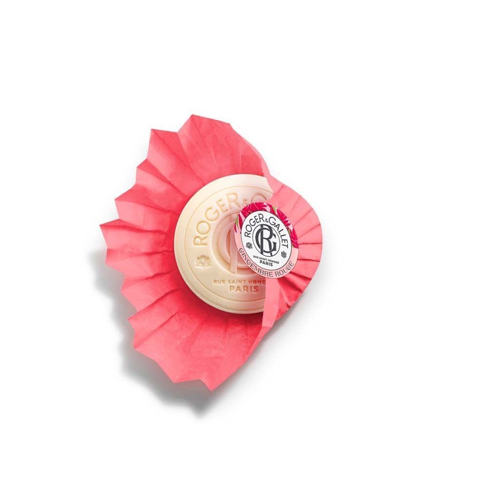 Eine runde, cremefarbene Seife in rosa Faltpapier. Das Logo von Roger & Gallet und der Schriftzug "Gingembre Rouge" sind sichtbar.