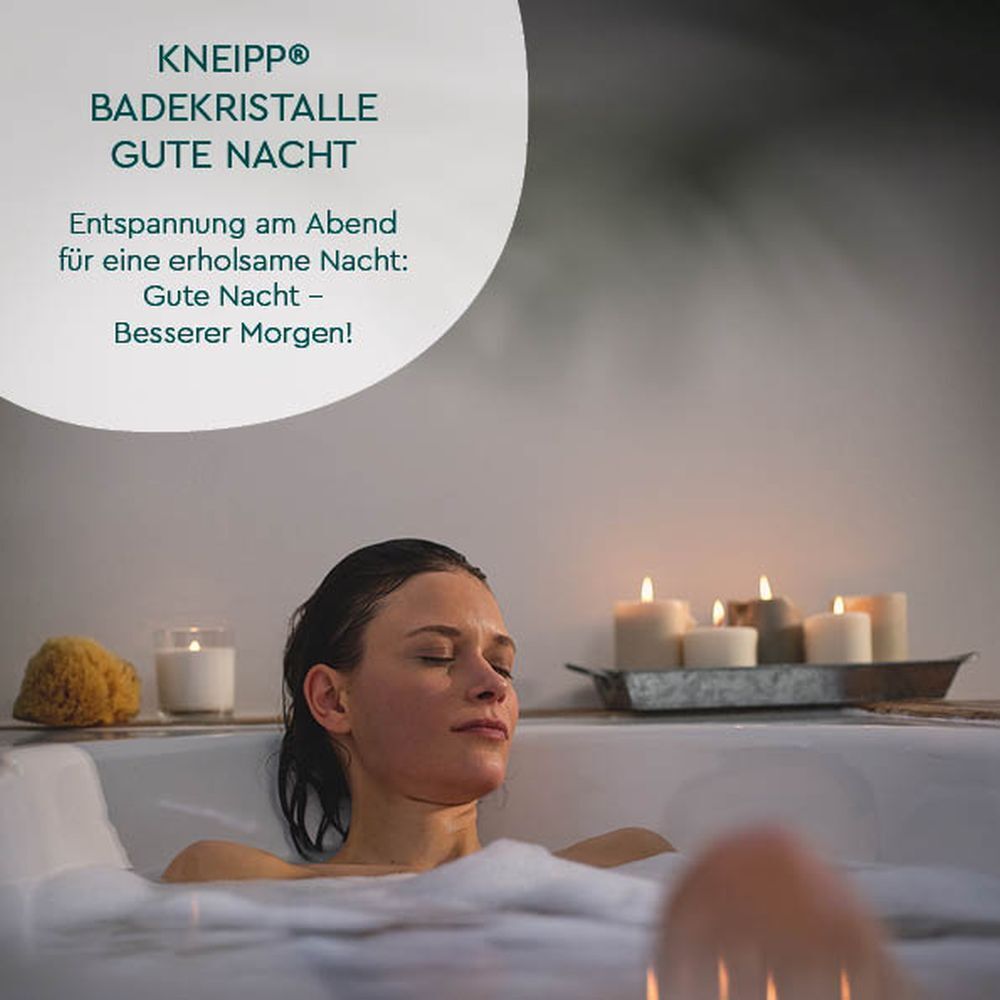 Frau in Badewanne mit Schaum. KNEIPP Badekristalle Gute Nacht. Kerzen im Hintergrund. Entspannung.