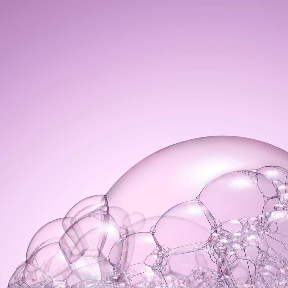 Nahaufnahme von Seifenblasen auf rosa Hintergrund. Blasen sind transparent und rund.
