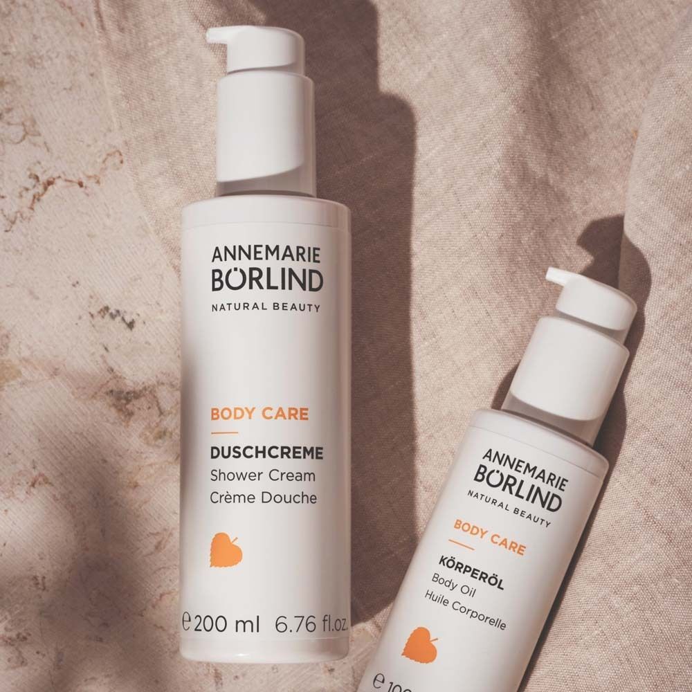 Zwei weiße Pumpflaschen: Duschcreme (200 ml) und Körperöl (100 ml).