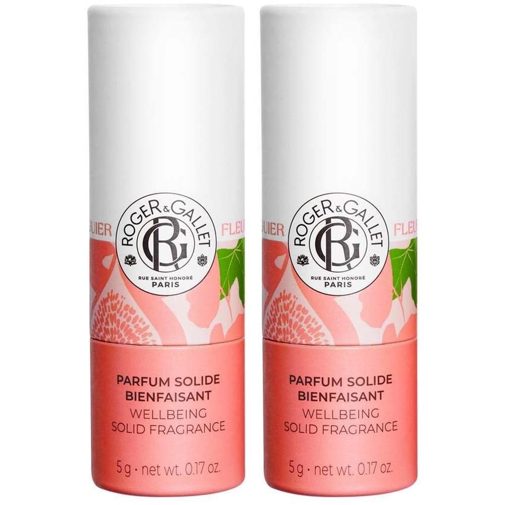 Zwei zylindrische Parfumsticks. Weißer Deckel mit Logo, rosafarbener Boden mit Text. Aufschrift: PARFUM SOLIDE BIENFAISANT WELLBEING SOLID FRAGRANCE.