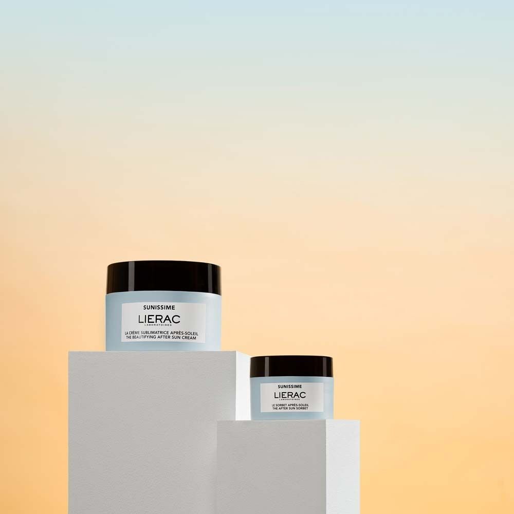 Zwei Tiegel auf Podesten. Aufschrift: LIERAC. Text: La crème sublimatrice après-soleil. The beautifying after sun cream. Ein kleinerer Tiegel.