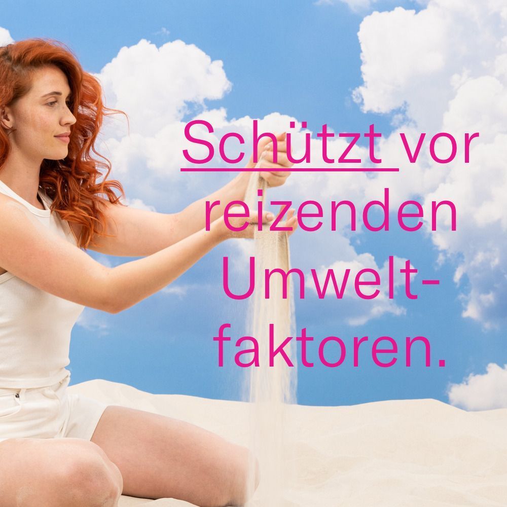 Frau mit rotem Haar, die Sand in die Luft wirft. Text: Schützt vor reizenden Umweltfaktoren.