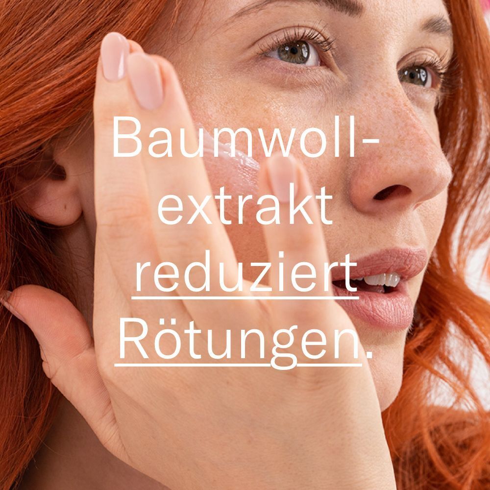 Frau berührt ihr Gesicht. Text: Baumwollextrakt reduziert Rötungen.