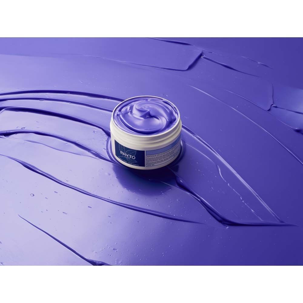 Ein offener Tiegel mit violettem Inhalt. Auf violettem Untergrund. Aufschrift: PHYTO PARIS.