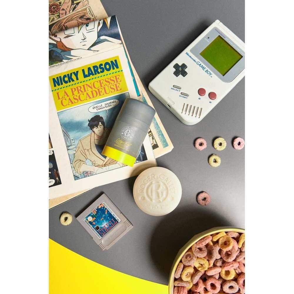 Deodorant-Stift mit gelbem Boden und grauer Hülle, neben Comic, Gameboy, Seife und Cerealien. Aufschrift: ROGER&GALLET, Cologne Twist.