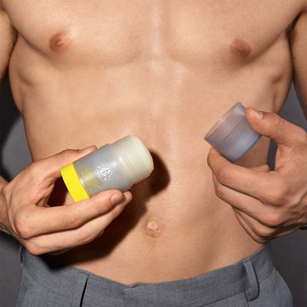 Person hält Deodorant-Stift mit gelbem Boden und grauer Hülle. Deckel abgenommen. Aufschrift: ROGER&GALLET, Cologne Twist.