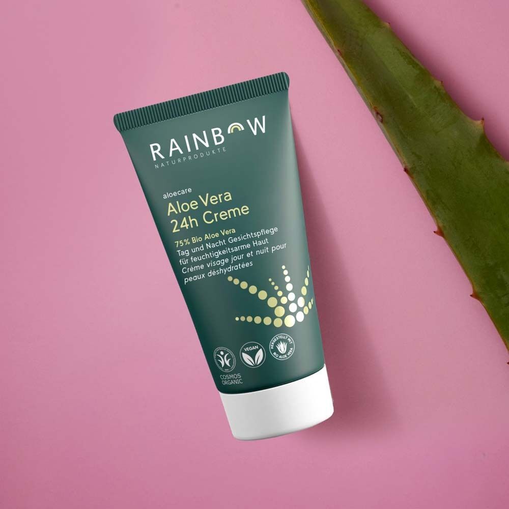 Grüne Tube Creme auf rosa Hintergrund. Aufschrift: Aloe Vera 24h Creme, 75% Bio Aloe Vera. Logos: Vegan, Cosmos Organic. Aloe-Blatt.