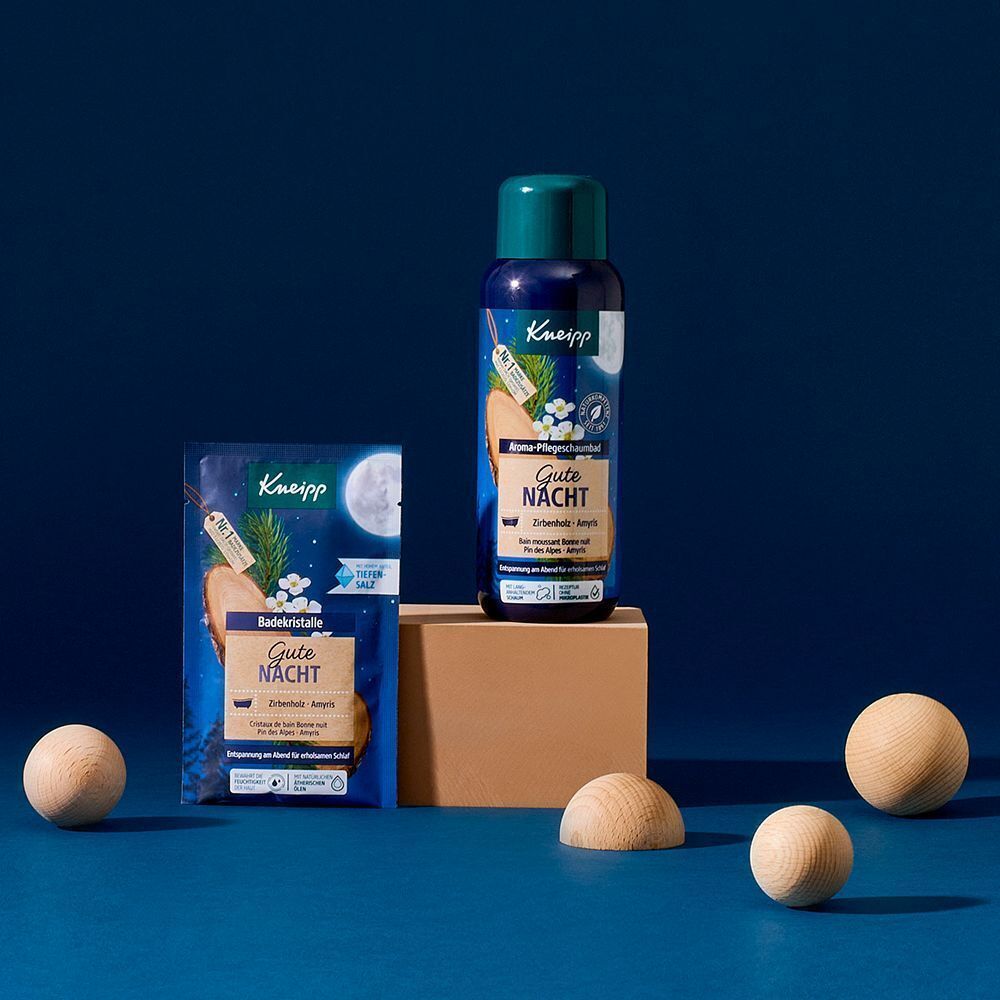 Produktflasche und Bade-Kristalle-Packung. Auf Holzsockel. Holz-Dekoration. Blauer Hintergrund.