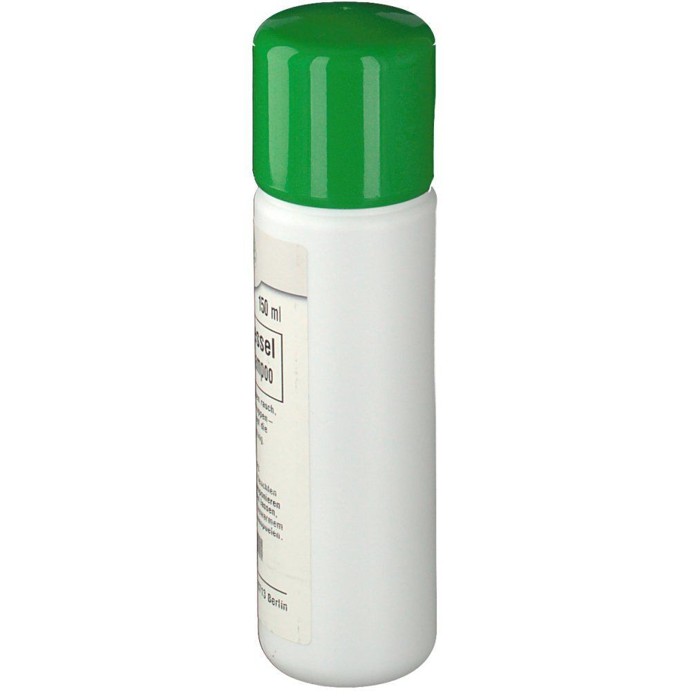 Eine weiße Shampoo-Flasche mit grünem Deckel. Seitenansicht.