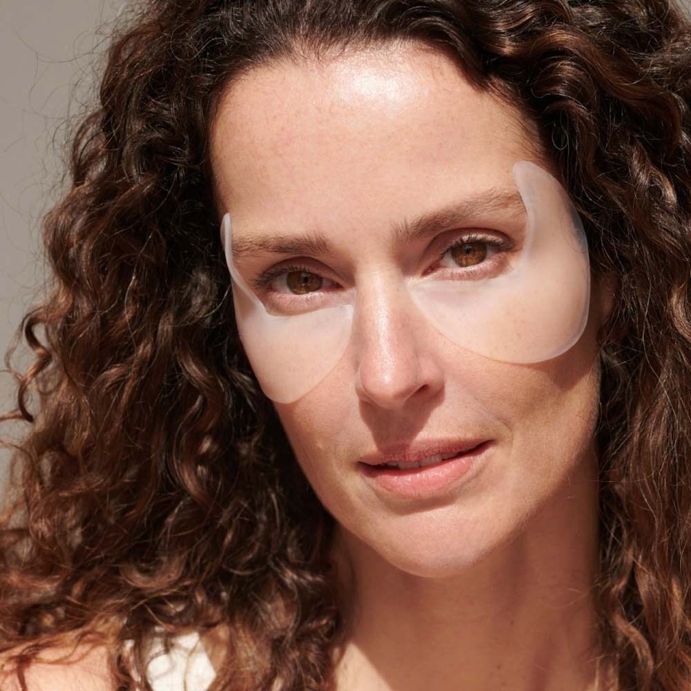 Frau mit Augen-Schläfen Pads auf der Haut. Pads sind transparent und halbmondförmig.