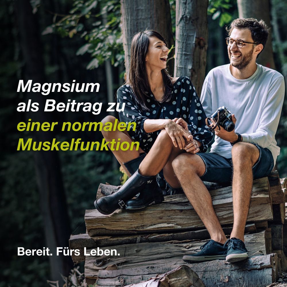 Ein Paar lacht in der Natur. Text: Magnesium als Beitrag zu einer normalen Muskelfunktion. Bereit. Fürs Leben.