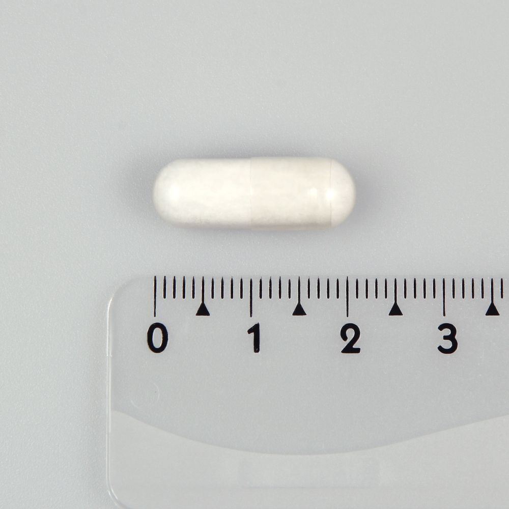 Eine einzelne, weiße Kapsel. Daneben ein Lineal mit Zentimetereinteilung. Die Kapsel ist etwa 2 cm lang.