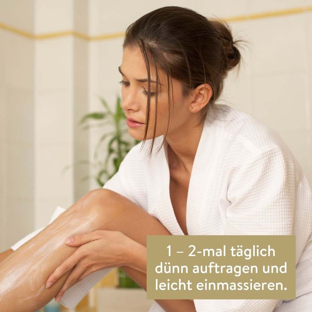 Frau trägt Lotion auf ihr Bein auf. Text: 1-2 mal täglich dünn auftragen und leicht einmassieren.