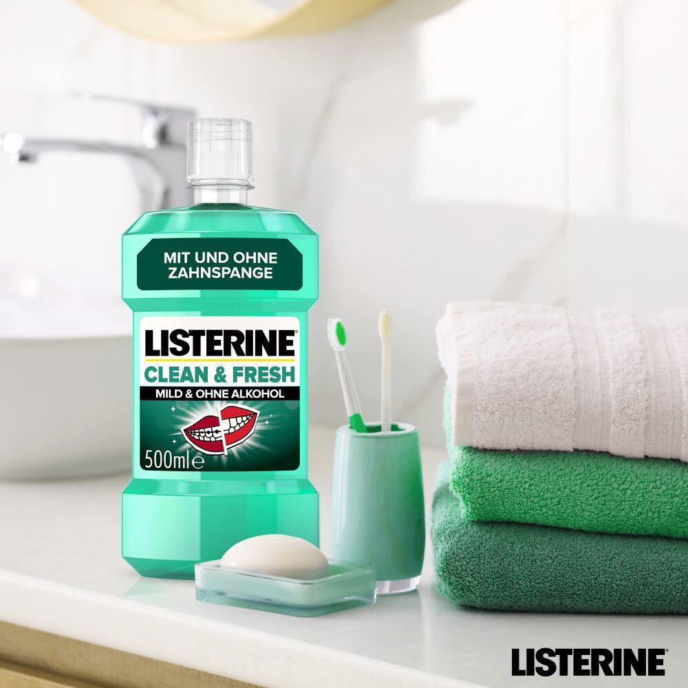 Flasche LISTERINE® Clean & Fresh auf Waschbecken. Daneben Zahnbürsten, Seife und Handtücher.