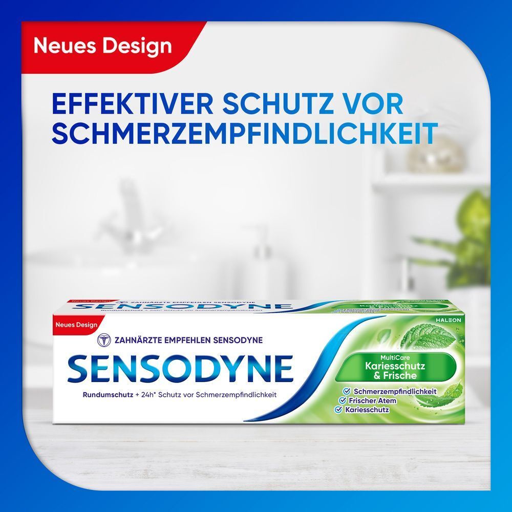 Sensodyne MultiCare Kariesschutz & Frische Zahnpasta. Weiß-blaue Verpackung mit grünen Akzenten. Text: Sensodyne, Kariesschutz & Frische. Hintergrund: Badezimmer.