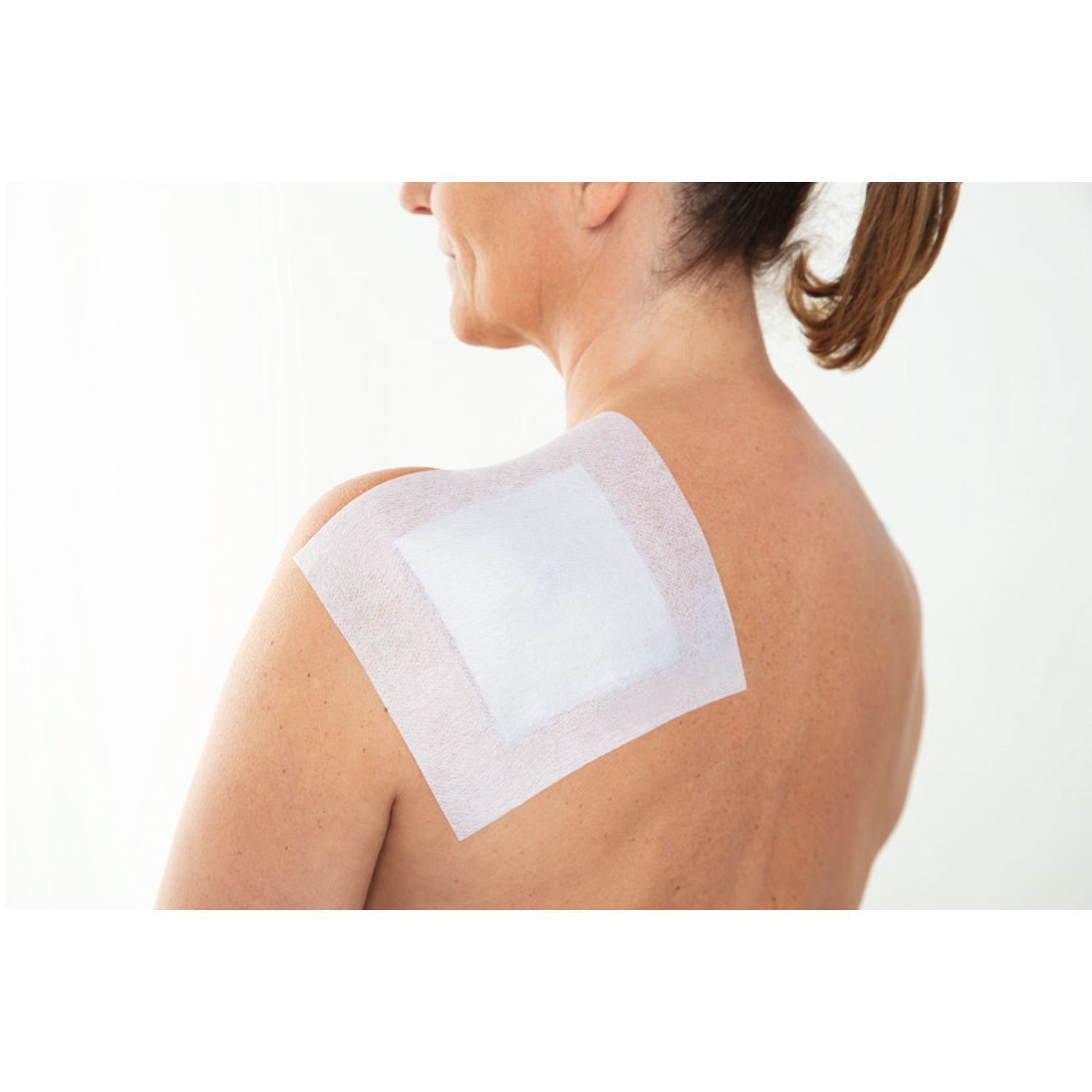 Verband auf dem Rücken einer Person. Der Verband ist weiß und rechteckig.