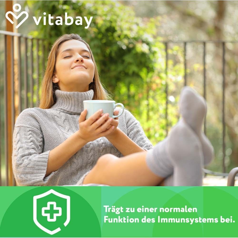 Frau mit geschlossenen Augen, hält eine Tasse. Text: Trägt zu einer normalen Funktion des Immunsystems bei.