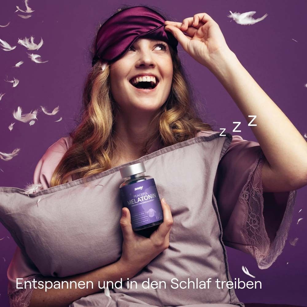 Eine Frau hält eine Flasche "sway Peaceful Melatonin" und ein Kissen. Sie trägt eine Schlafmaske und lächelt.