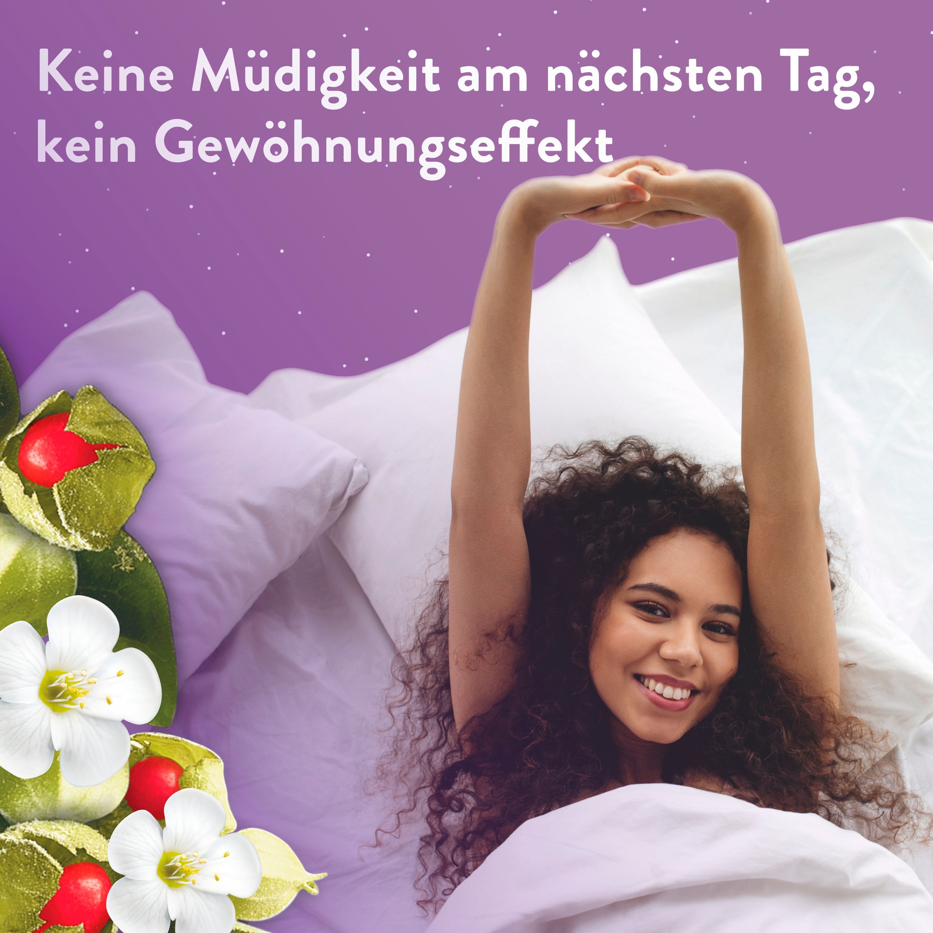 Eine Frau streckt sich lächelnd in einem Bett, umgeben von weißen Kissen.