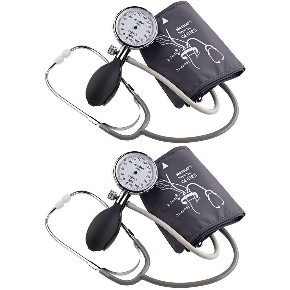 Zwei Blutdruckmessgeräte mit Stethoskopen. Graue Manschetten, runde Manometer, schwarze Pumpen und silberfarbene Stethoskope.