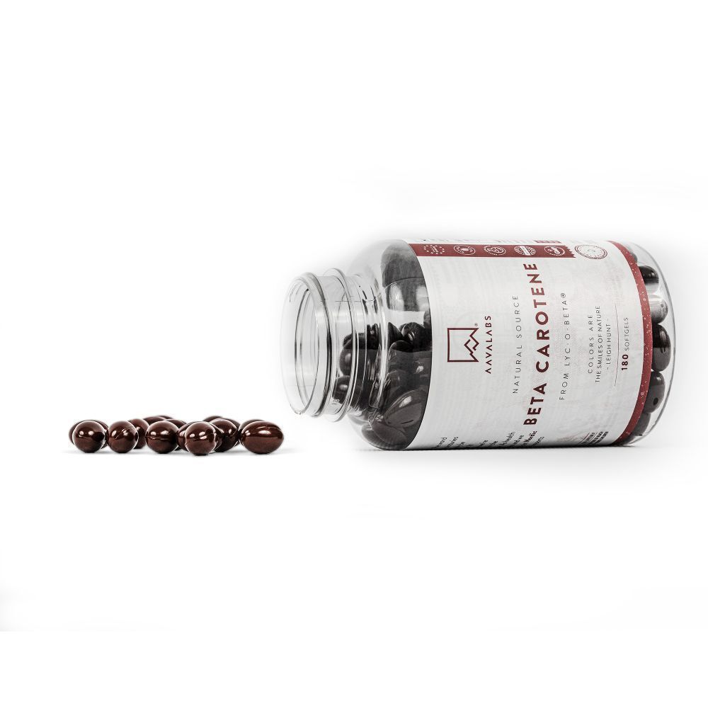 Flasche AAVALABS Beta Carotin liegt. Braune Kapseln daneben. Klare Flasche mit Produktinformationen.