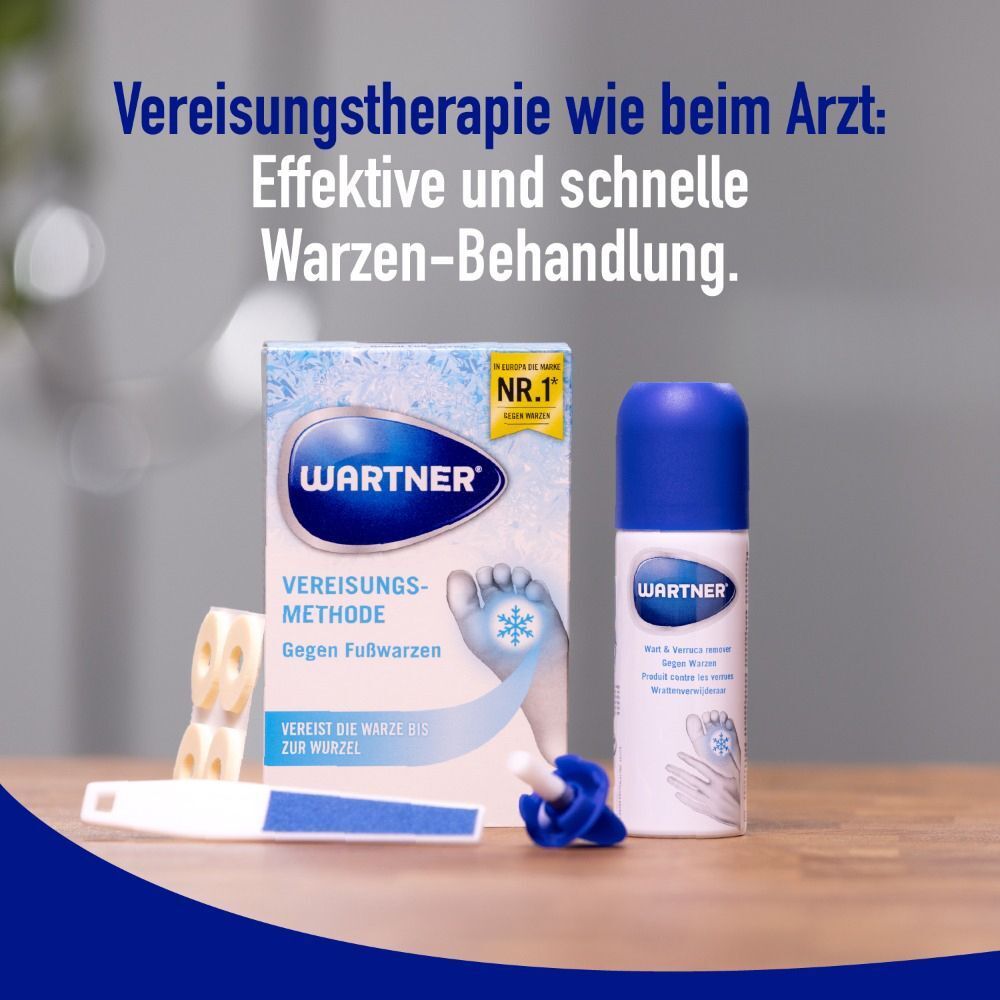 WARTNER Fußwarzen Spray, Zubehör und Produktinformationen auf einem Tisch. Spraydose, Feile, Applikator.