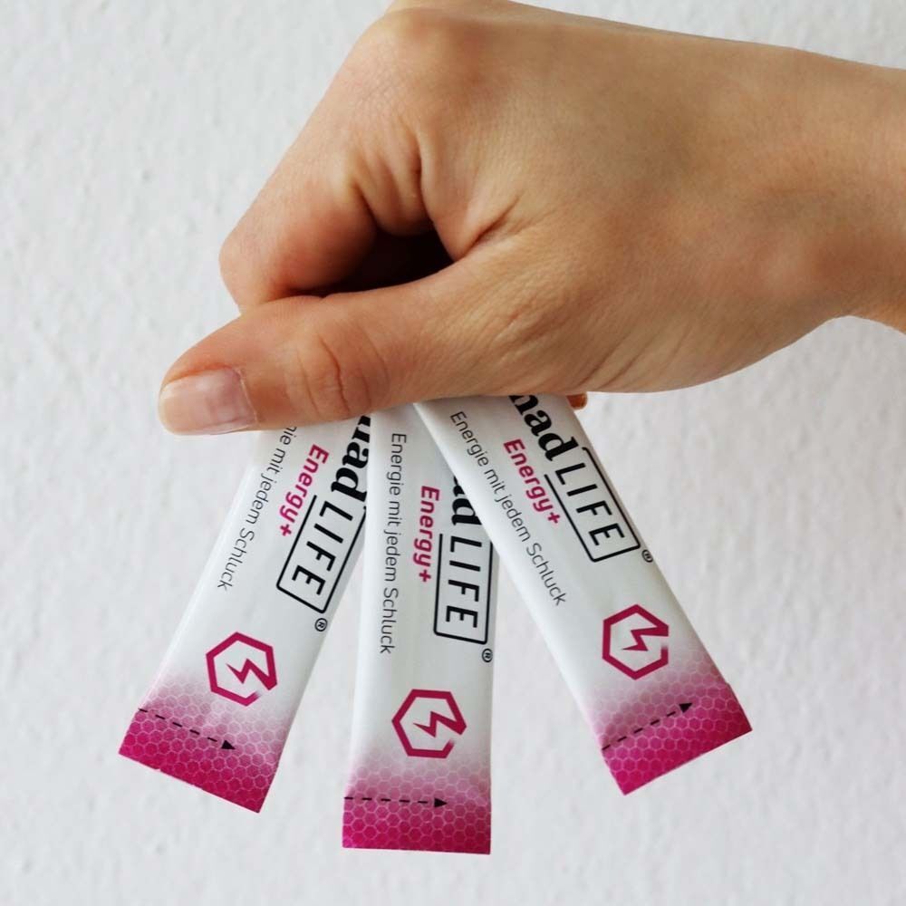 Hand hält drei Sachets nadLIFE® Energy+. Aufschrift: Energie mit jedem Schluck. Logo mit Blitz in einem Sechseck.