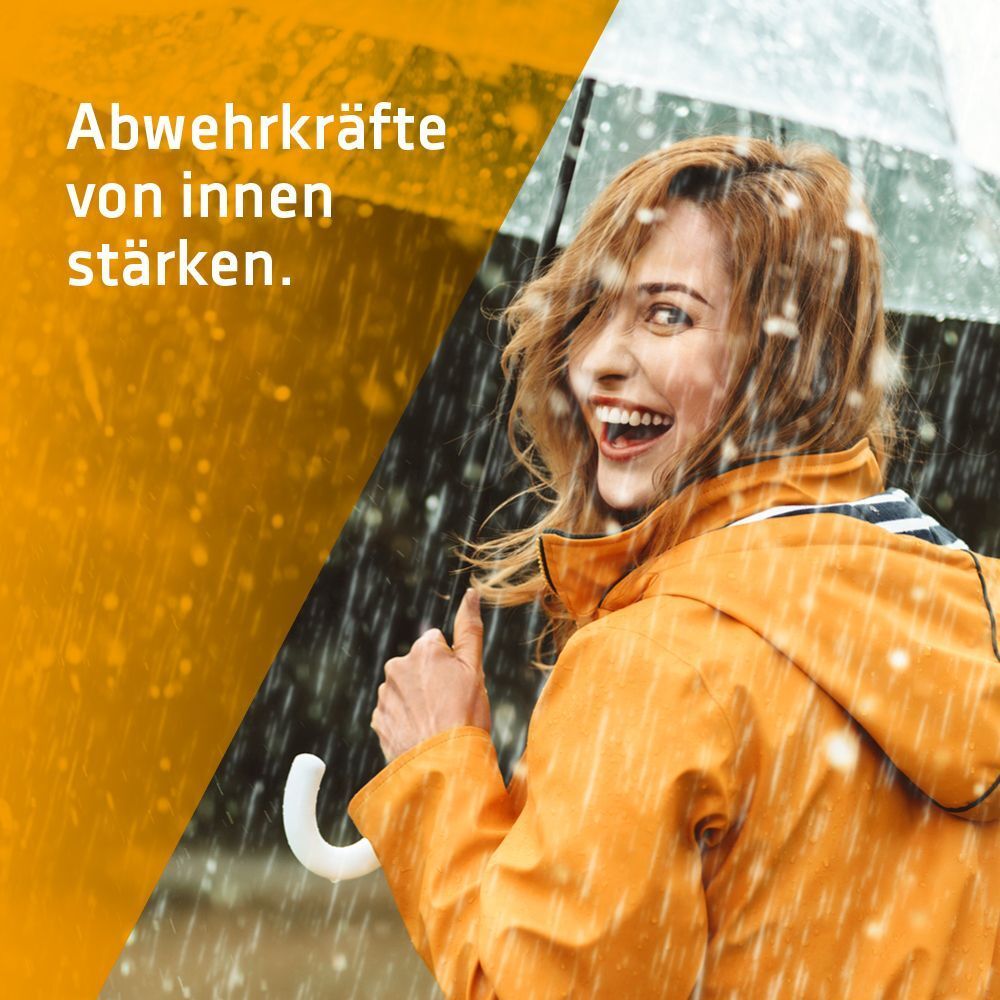 Frau mit Regenschirm im Regen, lächelnd, mit Text 'Abwehrkräfte von innen stärken'.