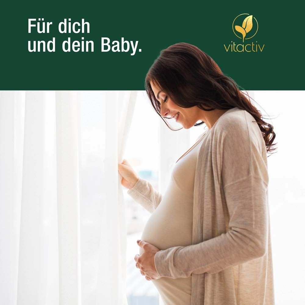 Schwangere Frau steht am Fenster, hält ihren Bauch. Text: Für dich und dein Baby. Logo: vitactiv.