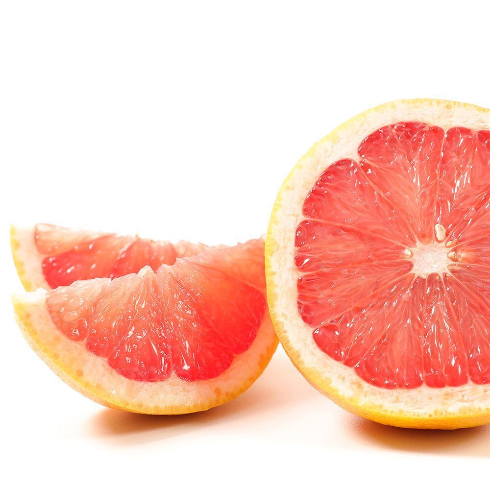 Nahaufnahme von drei rosa Grapefruit-Stücken. Auf weißem Hintergrund.