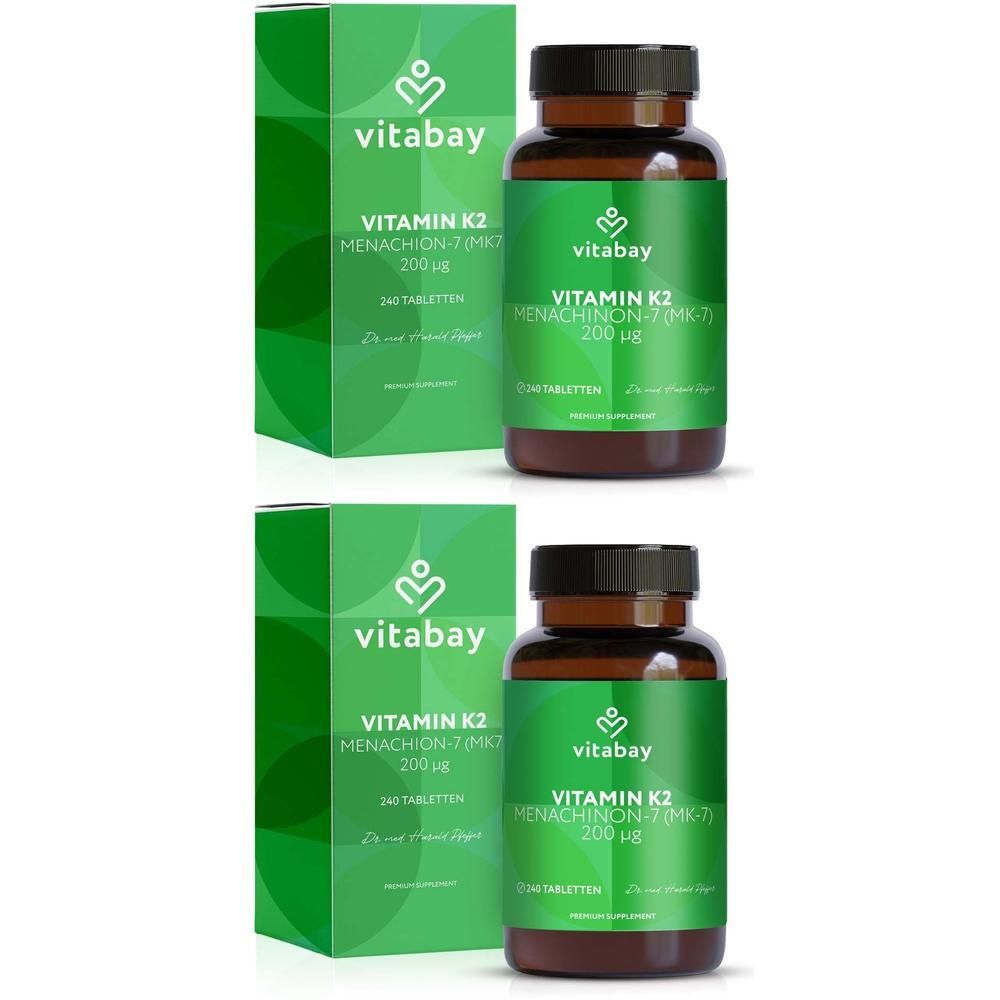 Zwei grüne Kartons und zwei braune Flaschen mit grünen Etiketten. Aufschrift: Vitamin K2 200 µg.